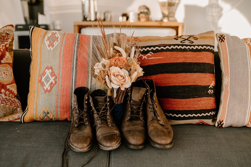 Bride and Groom's boots on the couch with desert flower bouquet