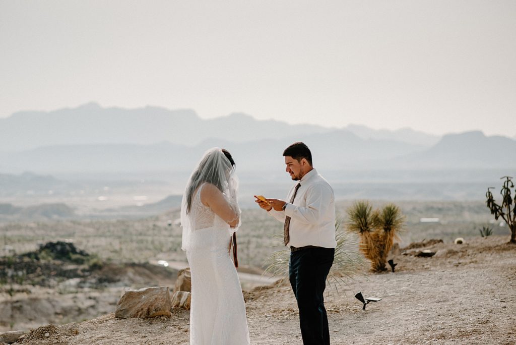 Groom reading vows to Bride out in the desert