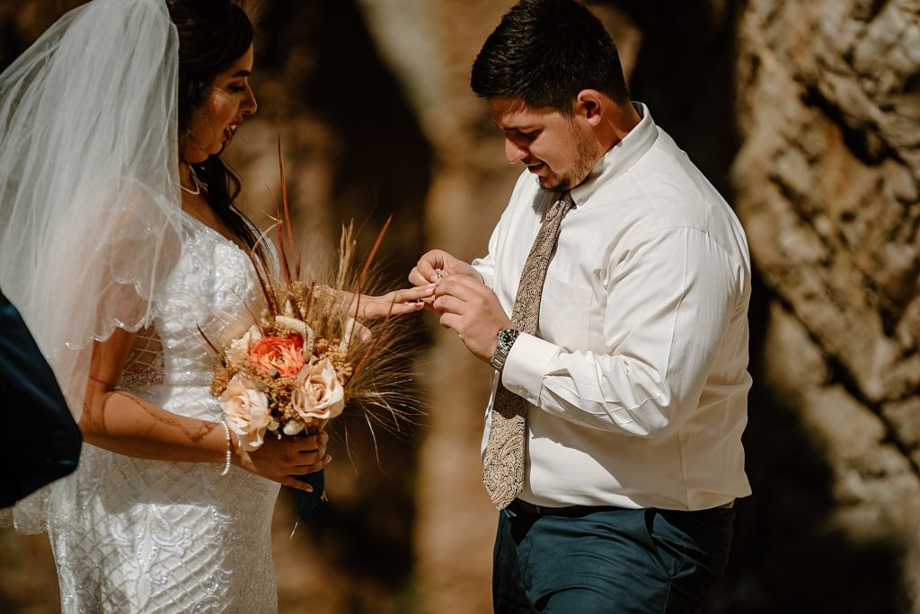 Groom putting ring on Bride during Elopement