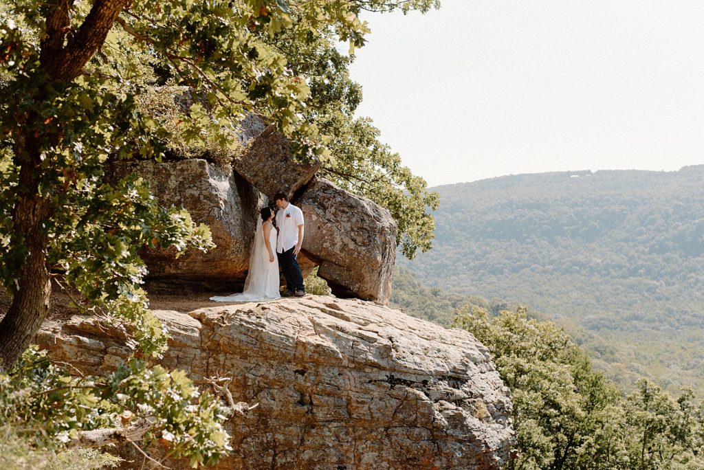 Couple looking at each other on rocky cliff side