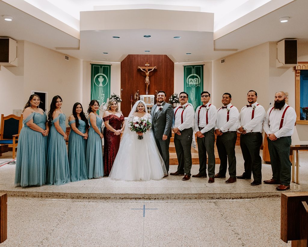 Bride and Groom with wedding party at front of church in formal formation