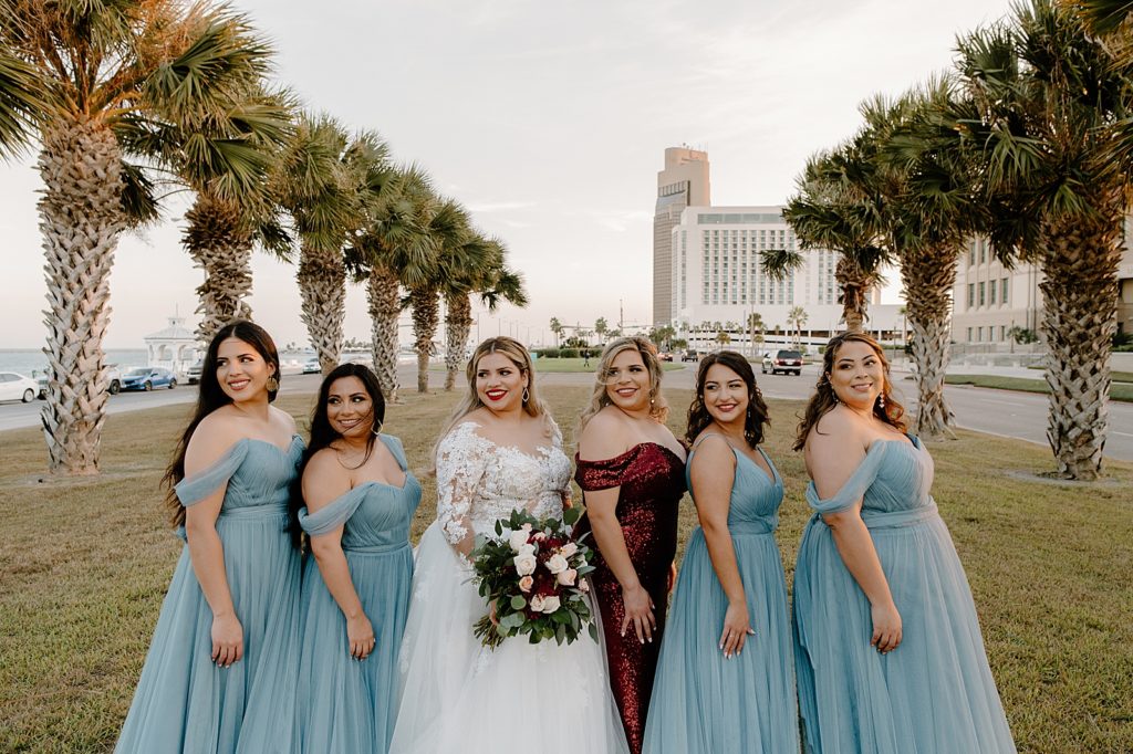 Bride posing with Bridesmaids by palm trees