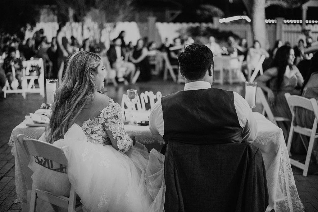 B&W Bride and Groom sitting at sweetheart table