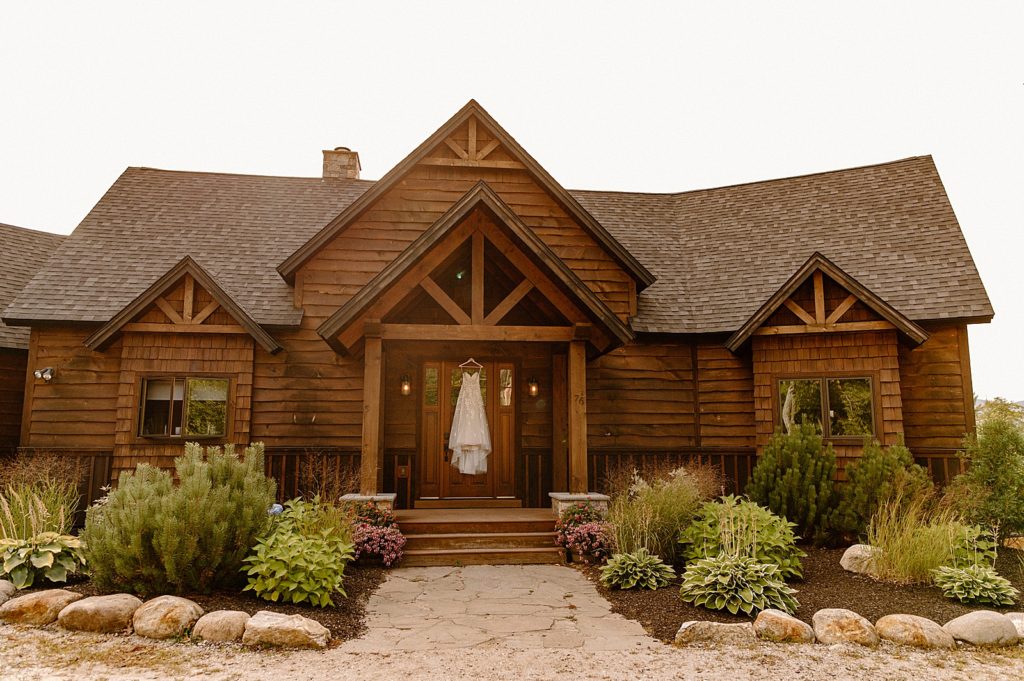 Detail shot of wood cabin with wedding dress hanging on front door