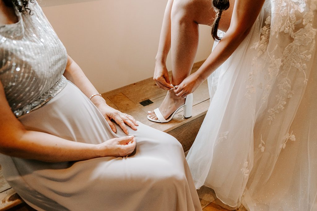 Bride strapping white heel getting ready