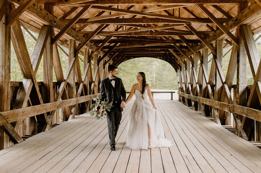 Bride and Groom holding hands and walking in wooden bridge