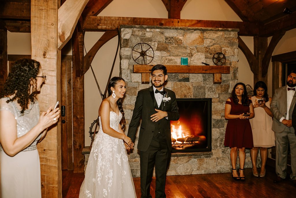 Bride and Groom entering Reception together by fireplace