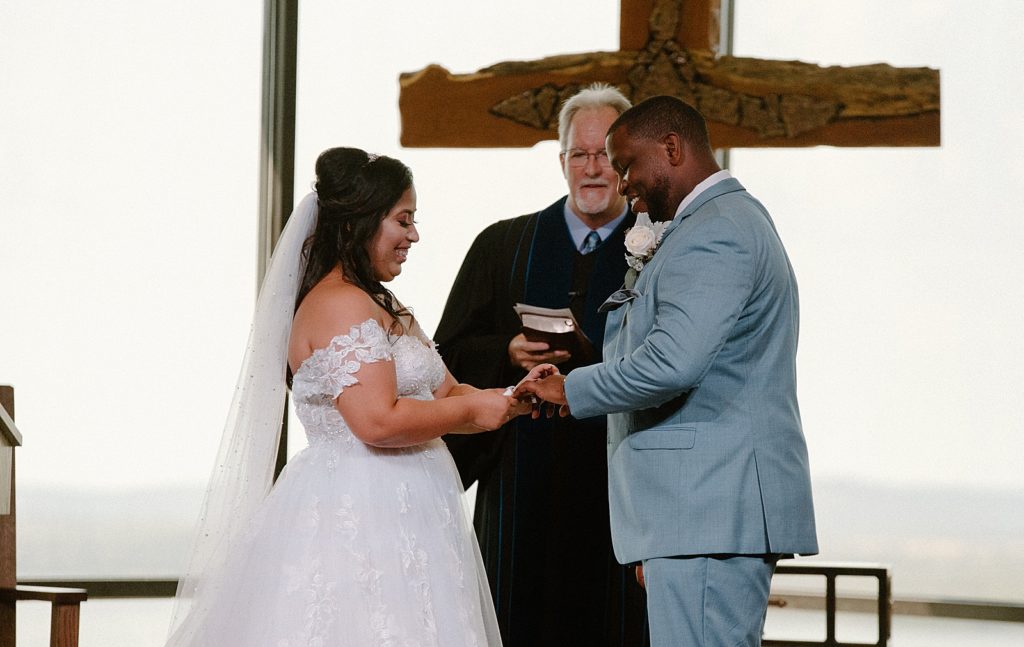 Bride putting ring on Groom during Ceremony