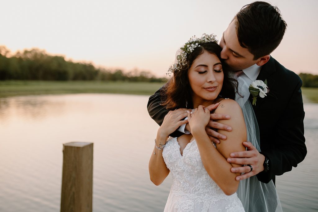 Groom holding Bride by the calm lake