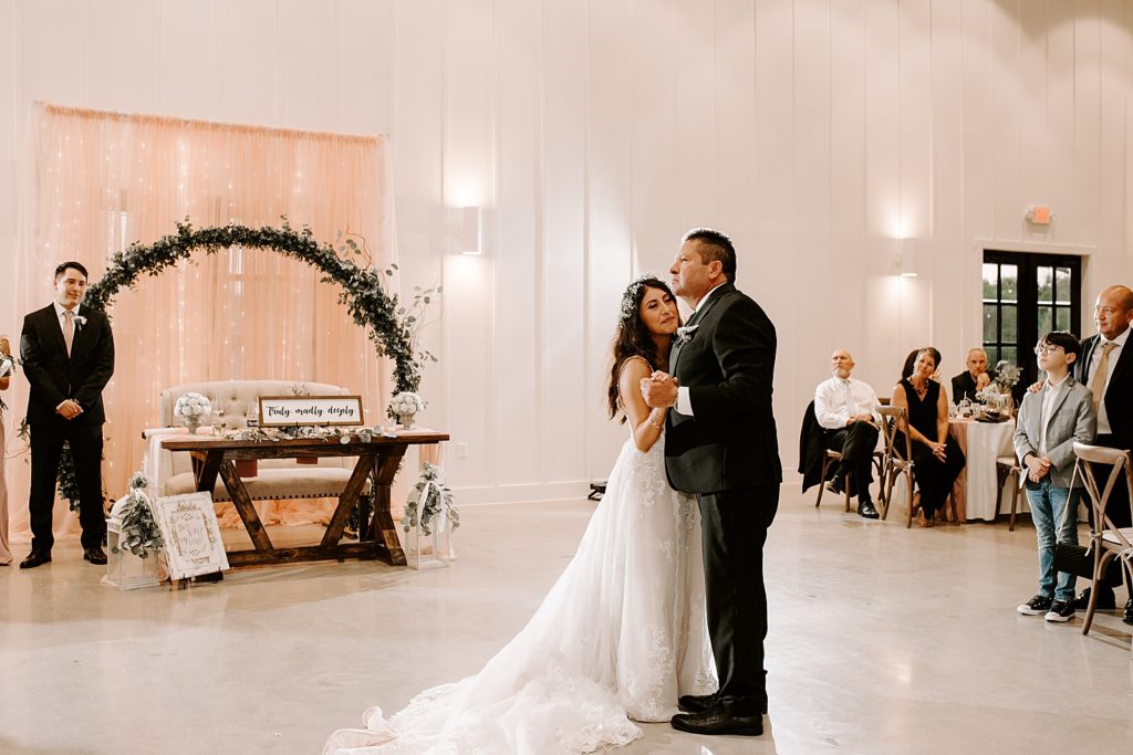 Father daughter dance with Groom watching by sweetheart table