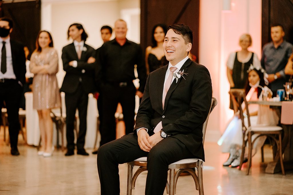 Groom enjoying live performance in chair at Reception