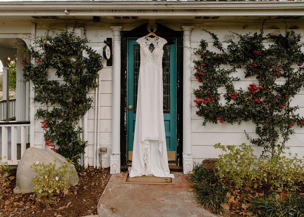 Wedding dress hanging on blue front door