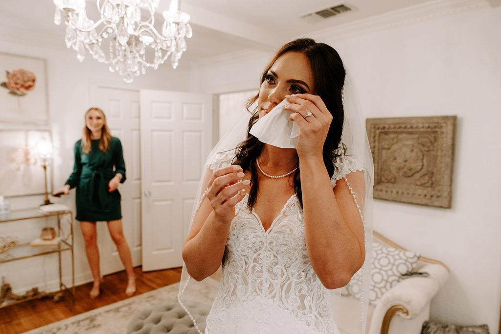 Bride wiping tears after getting ready
