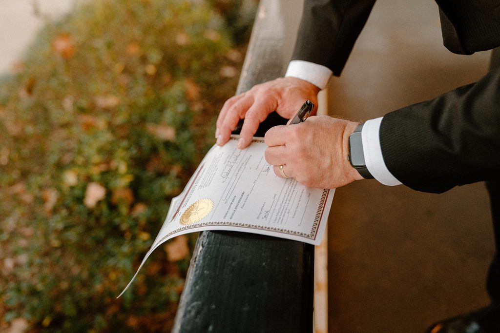 Closeup of someone signing Marriage certificate