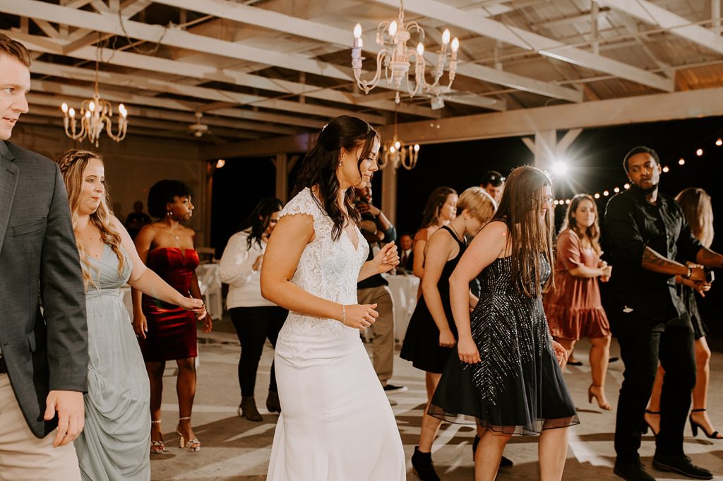Bride dancing with guests at night Reception