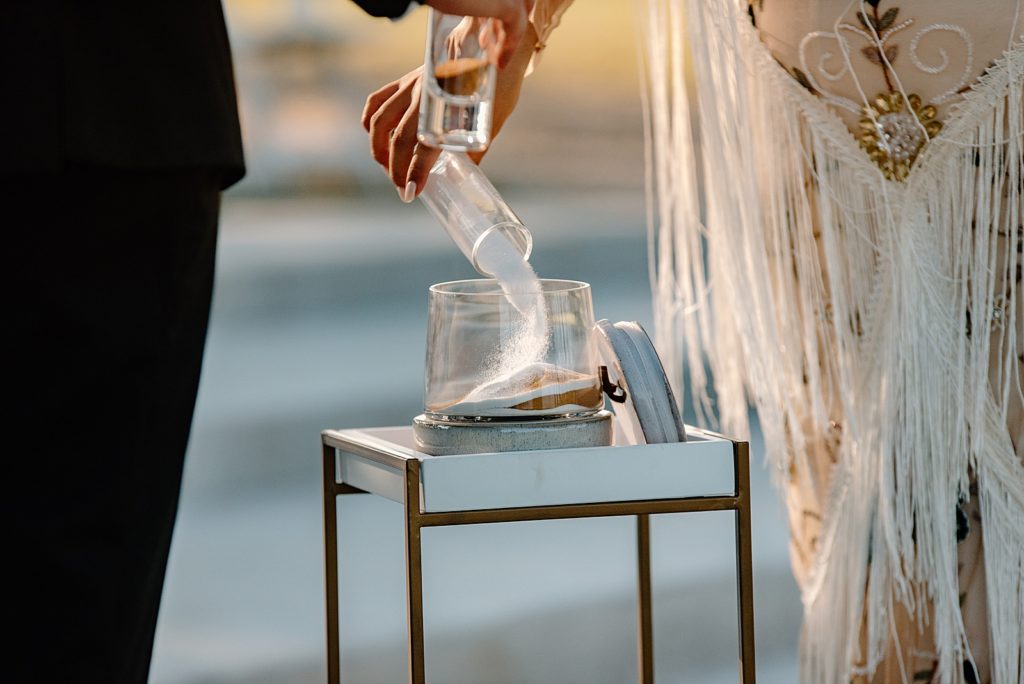 Closeup of Bride and Groom pouring sand for unity Ceremony