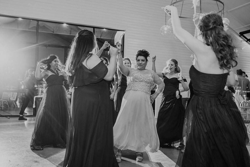 B&W Bride dancing with Bridesmaids around her