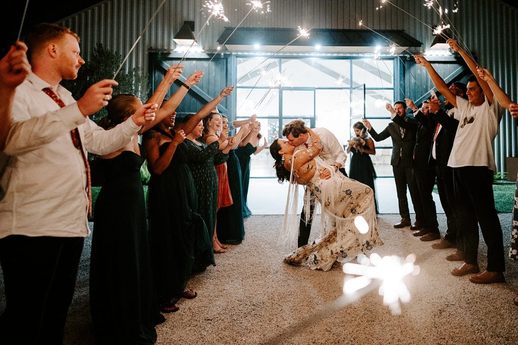 Bride and Groom dipping for sparkler exit at night